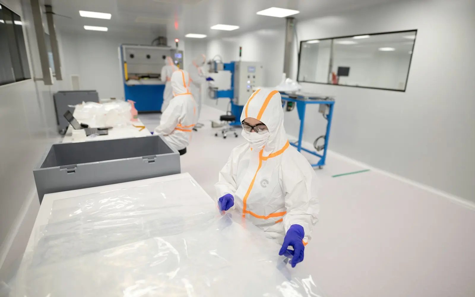 A technician in a cleanroom suit inside a pharmaceutical manufacturing unit